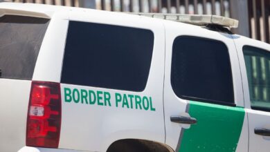 Border Patrol SUV near border fence