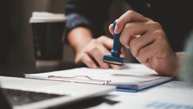Person stamping immigration documents on a desk